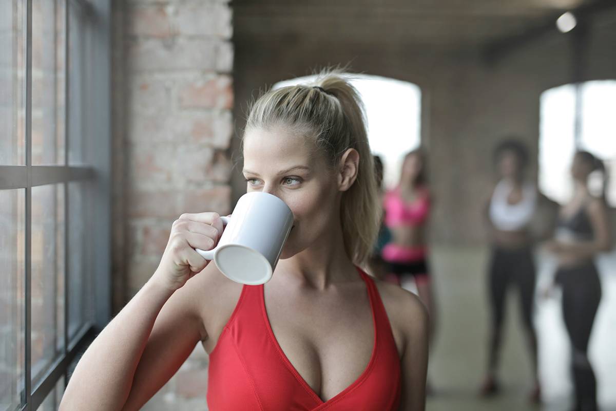 donna che beve caffè mentre fa sport